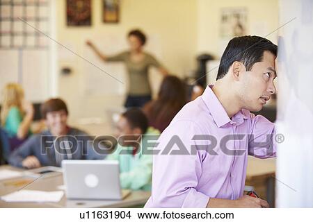 Picture - Stressed High School Teacher Trying To Control Class. Fotosearch