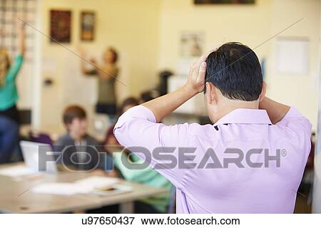 Stressed High School Teacher Trying To Control Class View Large Photo Image Stock Photo - Stressed High School Teacher Trying To Control Class. Fotosearch