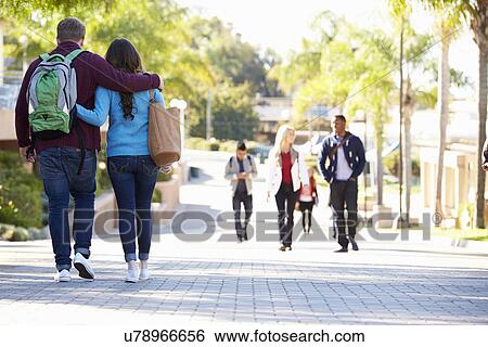 Stock Photograph - Student Couple Walking Outdoors On University Campus. Fotosearch