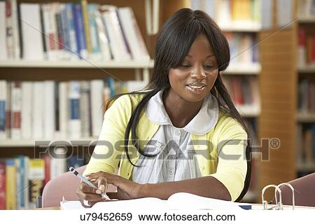Stock Photo - Student working in library. Fotosearch
