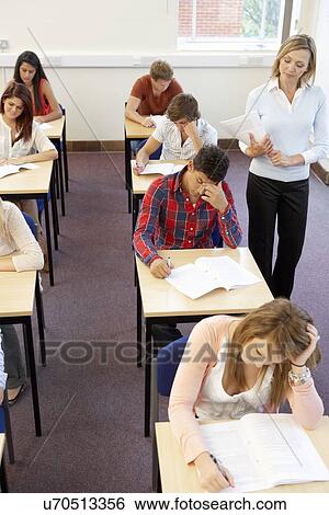 Stock Photograph - Students and tutor in exam. Fotosearch