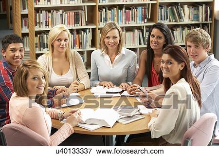 Students and tutor working in library View Large Photo Image Stock Photo - Students and tutor working in library. Fotosearch