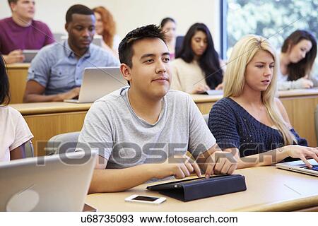 Stock Image - Students Using Laptops And Digital Tablets In Lecture. Fotosearch