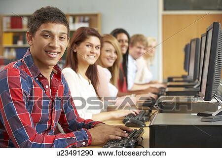 Stock Image - Students working on computers in library. Fotosearch