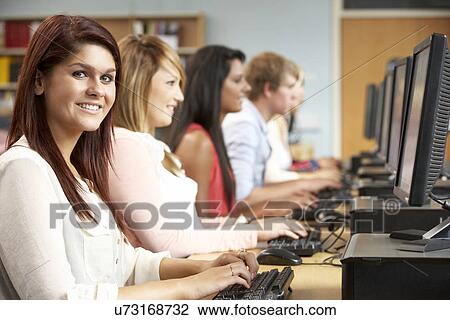 Stock Image - Students working on computers in library. Fotosearch