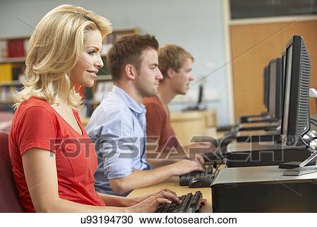 Stock Image - Students working on computers in library. Fotosearch