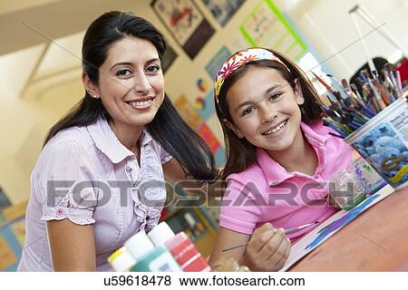 Stock Photo - Teacher and pupil in art class. Fotosearch
