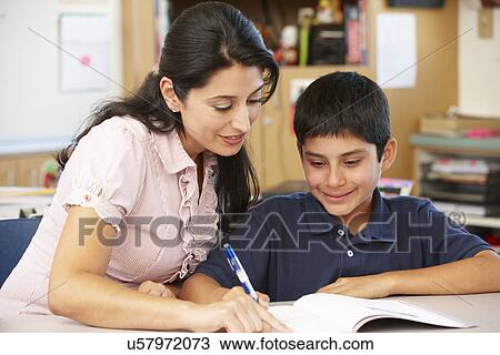 Stock Image - Teacher and schoolboy in class. Fotosearch