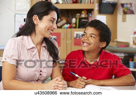 Stock Photograph - Teacher and schoolboy in class. Fotosearch