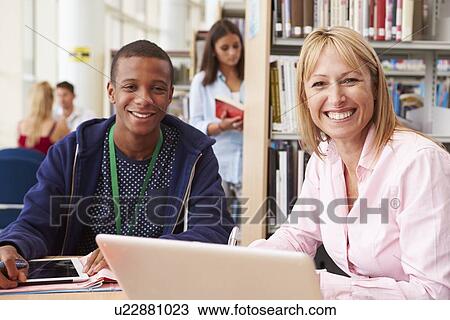 Teacher Helping College Student With Studies In Library View Large Photo Image Stock Image - Teacher Helping College Student With Studies In Library. Fotosearch