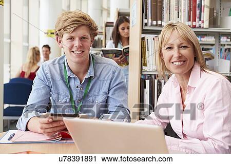 Teacher Helping College Student With Studies In Library View Large Photo Image Stock Image - Teacher Helping College Student With Studies In Library. Fotosearch