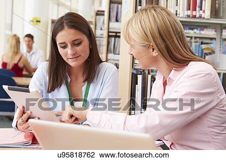 Teacher Helping College Student With Studies In Library View Large Photo Image Stock Image - Teacher Helping College Student With Studies In Library. Fotosearch