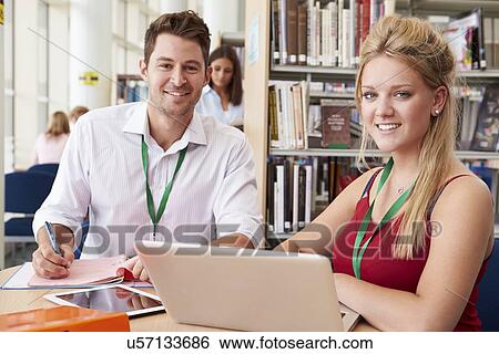 Teacher Helping College Student With Studies In Library View Large Photo Image Stock Photograph - Teacher Helping College Student With Studies In Library. Fotosearch
