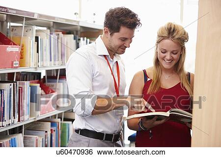 Teacher Helping College Student With Studies In Library View Large Photo Image Stock Photograph - Teacher Helping College Student With Studies In Library. Fotosearch