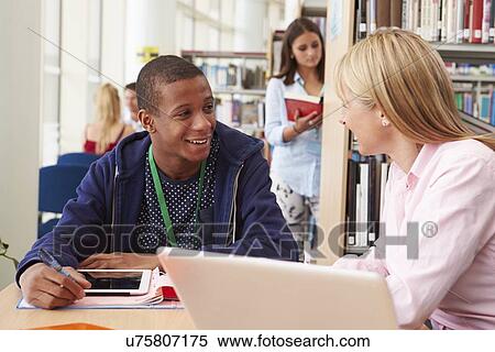 Teacher Helping College Student With Studies In Library View Large Photo Image Stock Photography - Teacher Helping College Student With Studies In Library. Fotosearch