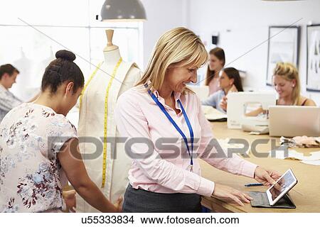 Picture - Teacher Helping College Students Studying Fashion And Design. Fotosearch