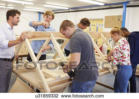 Stock Image - Teacher Helping College Students Studying Carpentry. Fotosearch