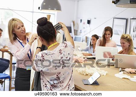 Stock Image - Teacher Helping College Students Studying Fashion And Design. Fotosearch
