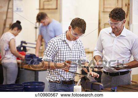 Stock Photo - Teacher Helping College Students Studying Plumbing. Fotosearch