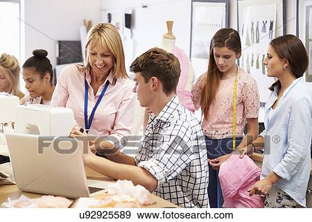 Stock Photo - Teacher Helping College Students Studying Fashion And Design. Fotosearch
