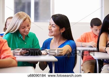 Teacher Helping Female High School Student In Classroom View Large Photo Image Picture - Teacher Helping Female High School Student In Classroom. Fotosearch
