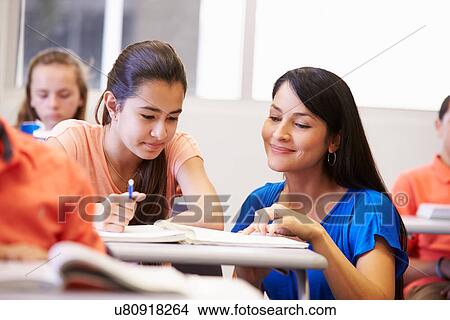Teacher Helping Female High School Student In Classroom View Large Photo Image Picture - Teacher Helping Female High School Student In Classroom. Fotosearch