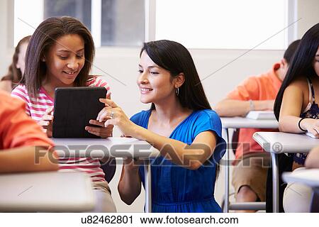 Teacher Helping Female High School Student In Classroom View Large Photo Image Stock Image - Teacher Helping Female High School Student In Classroom. Fotosearch