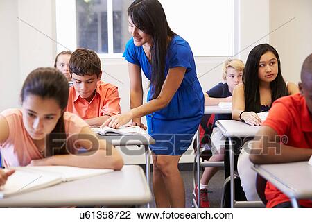 Teacher Helping Male High School Student In Classroom View Large Photo Image Stock Image - Teacher Helping Male High School Student In Classroom. Fotosearch