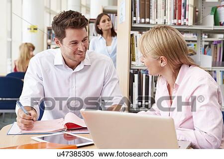 Teacher Helping Mature Student With Studies In Library View Large Photo Image Stock Photography - Teacher Helping Mature Student With Studies In Library. Fotosearch