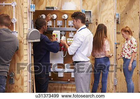 Teacher Helping Students Training To Be Electricians View Large Photo Image Stock Photo - Teacher Helping Students Training To Be Electricians. Fotosearch