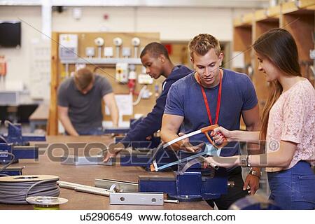 Stock Photo - Teacher Helping Students Training To Be Electricians. Fotosearch