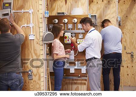 Stock Photography - Teacher Helping Students Training To Be Electricians. Fotosearch