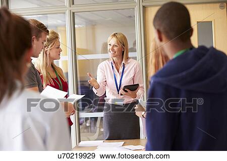 Teacher With College Students Standing By Desks In Classroom View Large Photo Image Stock Photo - Teacher With College Students Standing By Desks In Classroom. Fotosearch