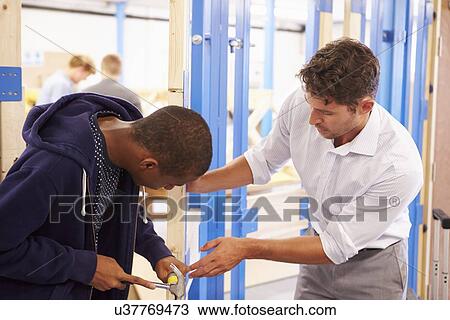 Teacher With Student In Carpentry Class Fitting Door Lock View Large Photo Image Stock Image - Teacher With Student In Carpentry Class Fitting Door Lock. Fotosearch