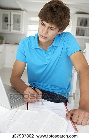 Teenage boy doing homework with laptop View Large Photo Image Stock Image - Teenage boy doing homework with laptop. Fotosearch