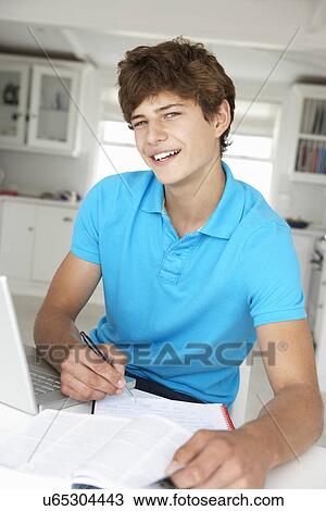Teenage boy doing homework with laptop View Large Photo Image Stock Image - Teenage boy doing homework with laptop. Fotosearch