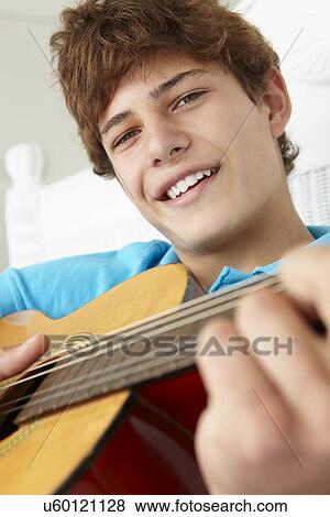 Teenage boy playing acoustic guitar View Large Photo Image Stock Photo - Teenage boy playing acoustic guitar. Fotosearch