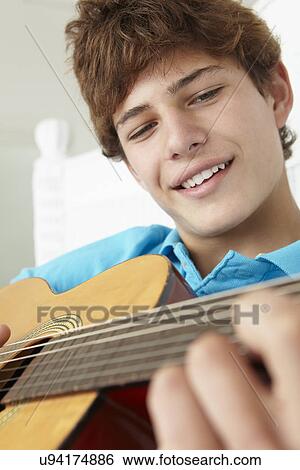 Teenage boy playing acoustic guitar View Large Photo Image Stock Photograph - Teenage boy playing acoustic guitar. Fotosearch