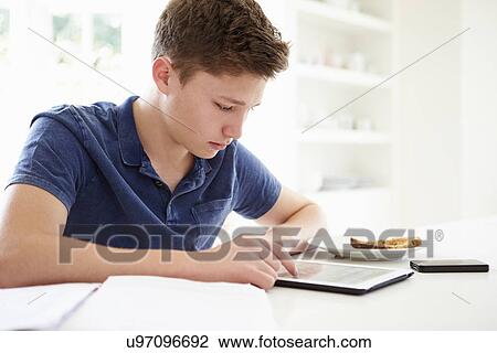 Teenage Boy Studying Using Digital Tablet At Home View Large Photo Image Stock Image - Teenage Boy Studying Using Digital Tablet At Home. Fotosearch