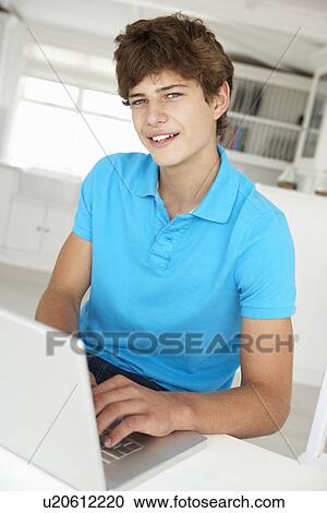 Stock Image - Teenage boy using laptop. Fotosearch