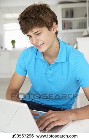 Stock Photograph - Teenage boy using laptop. Fotosearch