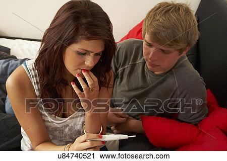 Stock Image - Teenage couple with pregnancy test. Fotosearch