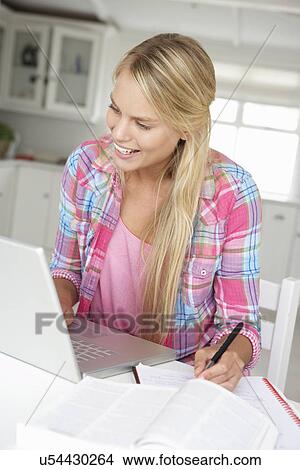 Picture - Teenage girl doing homework with laptop. Fotosearch