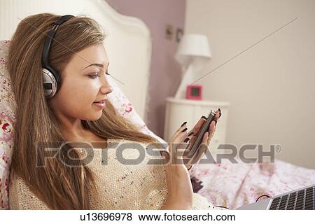Teenage Girl Lying On Bed Using Laptop Whilst Texting View Large Photo Image Stock Photo - Teenage Girl Lying On Bed Using Laptop Whilst Texting. Fotosearch