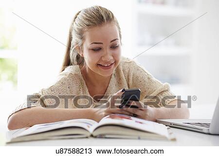 Teenage Girl Sending Text Message Whilst Studying On Laptop View Large Photo Image Stock Image - Teenage Girl Sending Text Message Whilst Studying On Laptop. Fotosearch