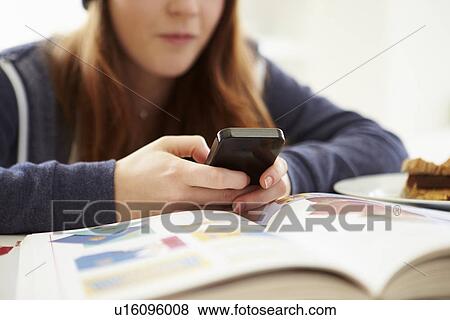 Teenage Girl Sending Text Message Whilst Studying View Large Photo Image Stock Photo - Teenage Girl Sending Text Message Whilst Studying. Fotosearch