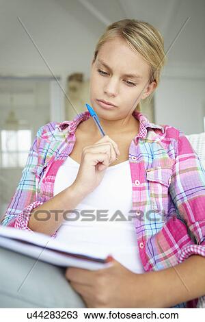 Stock Image - Teenage girl writing in notebook. Fotosearch