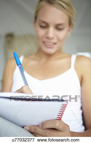 Teenage girl writing in notebook View Large Photo Image Stock Photo - Teenage girl writing in notebook. Fotosearch