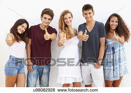 Stock Photo - Teenage Group Leaning Against Wall Giving Thumbs Up. Fotosearch
