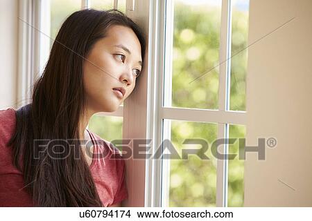 Picture - Thoughtful Asian Woman Looking Out Of Window. Fotosearch